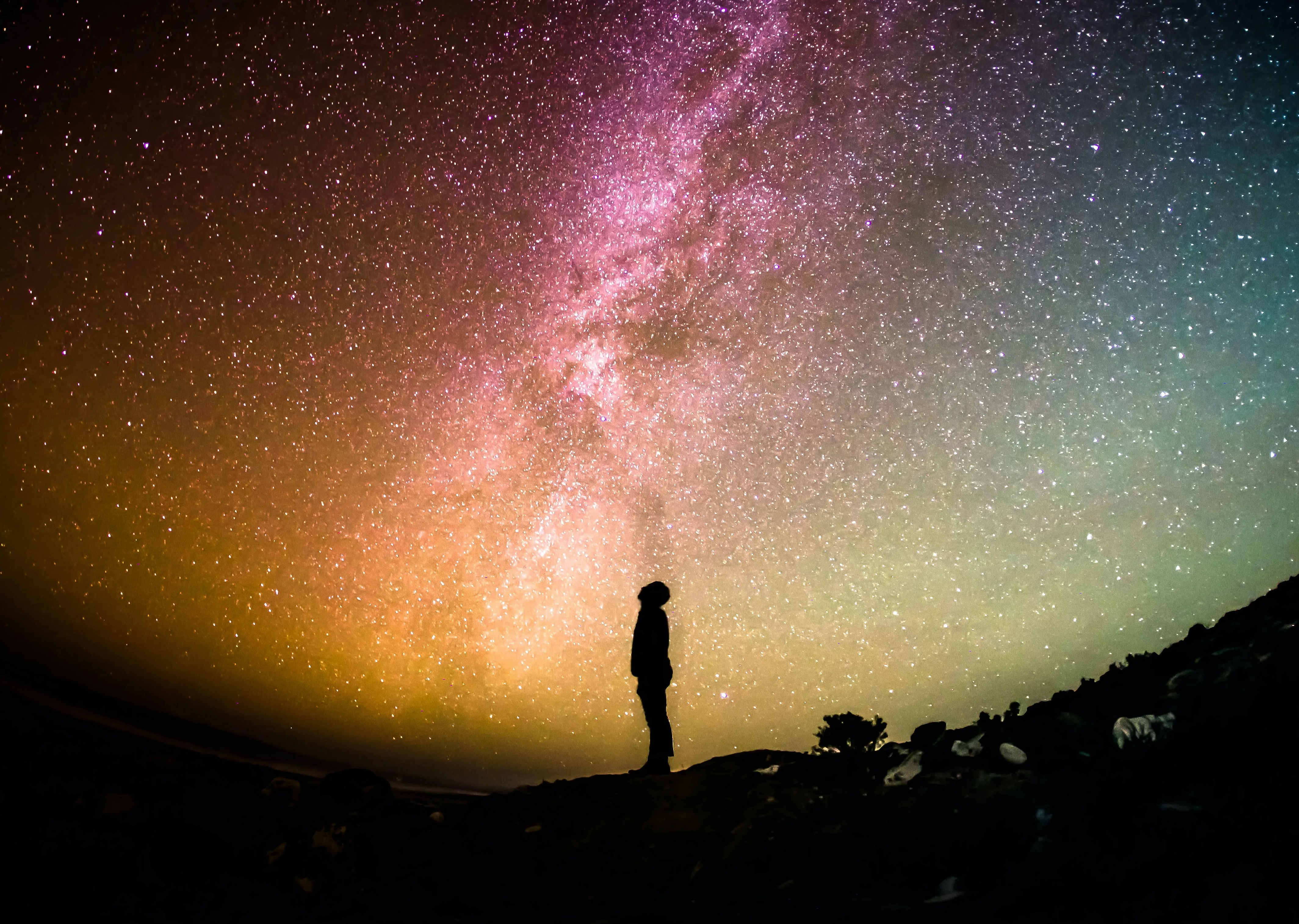 Das Bild zeigt einen Menschen der hoch in den Sternenhimmel schaut.  Urheber ist Greg Rakozy der das Bild über Unsplash zur Verfügung gestellt hat. https://unsplash.com/de/fotos/oMpAz-DN-9I
